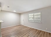 Thumbnail 28 of 30 - A room with wooden flooring and a window with blinds.