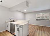 Thumbnail 21 of 30 - A kitchen with white cabinets and a wooden floor.