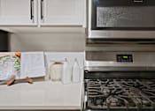 Thumbnail 9 of 30 - A kitchen with a stove and a microwave oven.