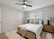 Thumbnail 14 of 30 - A bedroom with a bed, nightstand, and ceiling fan.