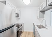Thumbnail 21 of 42 - A modern kitchen with stainless steel appliances and white countertops at Water Ridge Apartments , Texas, 75061