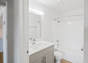 Thumbnail 29 of 42 - A white bathroom with a toilet, sink, and bathtub at Water Ridge Apartments , Irving, Texas