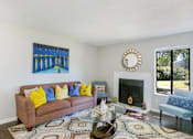 Thumbnail 19 of 42 - A living room with a brown couch, a coffee table, and a painting on the wall at Water Ridge Apartments , Irving, 75061