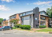 Thumbnail 5 of 42 - A grey car is parked in front of a building with a blue sign on it at Water Ridge Apartments , Irving