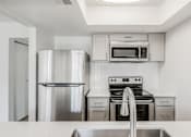Thumbnail 24 of 42 - A modern kitchen with stainless steel appliances and white cabinets at Water Ridge Apartments , Irving, 75061