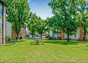 Thumbnail 35 of 42 - A park with a picnic table surrounded by trees and buildings at Water Ridge Apartments , Irving, Texas