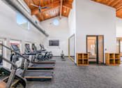 Thumbnail 11 of 42 - A gym with treadmills, exercise bikes, and a television at Water Ridge Apartments , Irving, TX, 75061