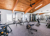 Thumbnail 10 of 42 - A gym with a variety of equipment including weights and machines at Water Ridge Apartments , Irving