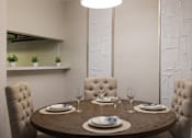 Thumbnail 30 of 35 - A dining table set with plates and glasses is ready for a meal.