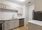 Thumbnail 34 of 35 - A kitchen with white cabinets and a black refrigerator.