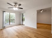 Thumbnail 6 of 35 - A room with a ceiling fan and wooden flooring.