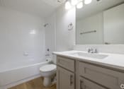 Thumbnail 35 of 35 - A white toilet sits in a bathroom next to a sink.