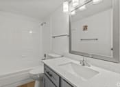Thumbnail 5 of 37 - A white bathroom with a toilet, sink, and mirror.