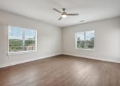 Thumbnail 16 of 35 - an empty living room with wood floors and a ceiling fan at The Virginia, Seguin
