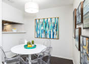 Thumbnail 10 of 35 - our apartments have a small dining room with a white table and chairs  at Sunset Canyon, San Antonio, TX