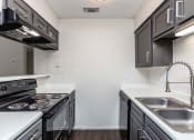 Thumbnail 13 of 35 - a kitchen with a stove top oven next to a sink  at Sunset Canyon, San Antonio, Texas