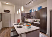 Thumbnail 3 of 22 - a kitchen with a granite counter top at The Grand at Stonecreek, Texas, 78666