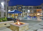 Thumbnail 15 of 22 - an outdoor area with a fire pit and a pool at night at The Grand at Stonecreek, San Marcos, TX, 78666
