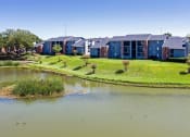 Thumbnail 35 of 55 - an apartment building next to a body of water at Water Ridge Apartments, Irving, TX 75061