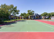 Thumbnail 33 of 55 - a tennis court with trees and apartments in the background at Water Ridge Apartments, Irving, 75061