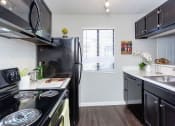 Thumbnail 41 of 55 - a kitchen with black appliances and a window at Water Ridge Apartments, Irving, TX