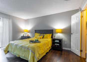Thumbnail 7 of 55 - a bedroom with a yellow comforter on a bed at Water Ridge Apartments, Texas, 75061