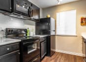 Thumbnail 2 of 55 - a kitchen with a stove and a microwave at Water Ridge Apartments, Irving
