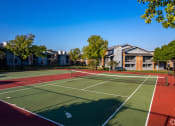 Thumbnail 54 of 55 - a tennis court with apartments in the background at Water Ridge Apartments, Irving, TX 75061