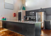 Thumbnail 53 of 55 - the kitchen has stainless steel appliances and a granite counter top at Water Ridge Apartments, Irving