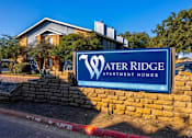 Thumbnail 19 of 55 - A sign for Water Ridge Apartment Homes in front of a building.