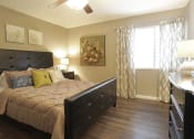 Thumbnail 10 of 55 - a bedroom with a bed and a ceiling fan at Water Ridge Apartments, Irving, Texas