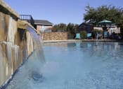 Thumbnail 23 of 55 - a large swimming pool with water coming out of it at Water Ridge Apartments, Texas