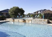 Thumbnail 20 of 55 - a large pool with a house in the background at Water Ridge Apartments, Irving, Texas