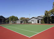 Thumbnail 31 of 55 - a tennis court with houses and trees in the background at Water Ridge Apartments, Irving, TX
