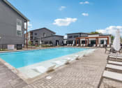 Thumbnail 8 of 35 - a swimming pool with chairs and umbrellas next to a building at The Virginia, Texas, 78155