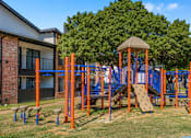 Thumbnail 13 of 42 - A playground with a slide, swings, and a climbing frame at Water Ridge Apartments , Irving, Texas