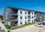 Thumbnail 49 of 52 - A modern apartment complex with a parking lot in front at The Virginia Apartments , Seguin, Texas
