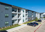Thumbnail 50 of 52 - A parking lot in front of a building with cars parked at The Virginia Apartments , Texas