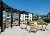 Thumbnail 15 of 52 - A patio area with chairs and a table at The Virginia Apartments , Seguin, Texas