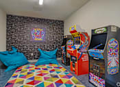 Thumbnail 13 of 52 - A room with a colorful carpet and a wall with a picture of a game zone. at The Virginia Apartments , Texas