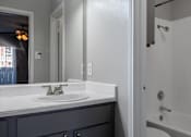 Thumbnail 10 of 42 - A bathroom with a white sink and a white tub.