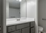 Thumbnail 11 of 42 - A bathroom with a white sink and grey drawers.