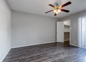Thumbnail 2 of 42 - A room with a ceiling fan and wooden flooring.