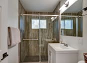 Thumbnail 13 of 23 - A bathroom with a walk-in shower and a white sink.
