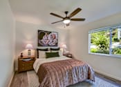 Thumbnail 9 of 23 - A bedroom with a bed, nightstands, and a ceiling fan.