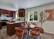 Thumbnail 6 of 23 - A kitchen with a table and chairs in the middle of the room.