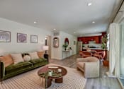 Thumbnail 3 of 23 - A living room with a green couch and a coffee table.
