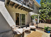 Thumbnail 17 of 23 - A patio with a chair and table outside a house.