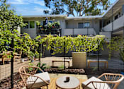 Thumbnail 16 of 23 - A patio with chairs and a table surrounded by a fence.