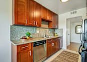 Thumbnail 12 of 39 - A kitchen with wooden cabinets and a granite countertop.
